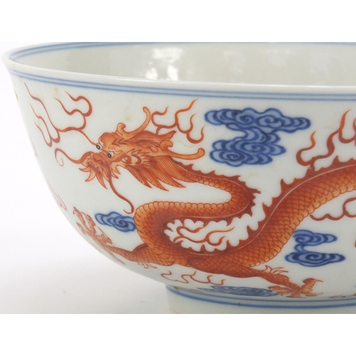 250 - Chinese iron red and blue and white porcelain bowl, finely hand painted with two dragons chasing a f... 