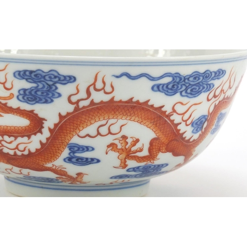 250 - Chinese iron red and blue and white porcelain bowl, finely hand painted with two dragons chasing a f... 