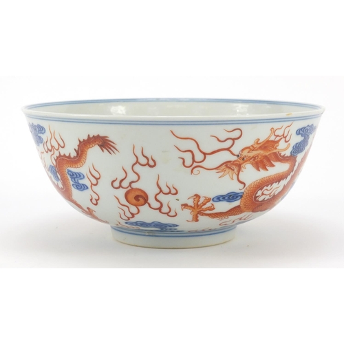 250 - Chinese iron red and blue and white porcelain bowl, finely hand painted with two dragons chasing a f... 