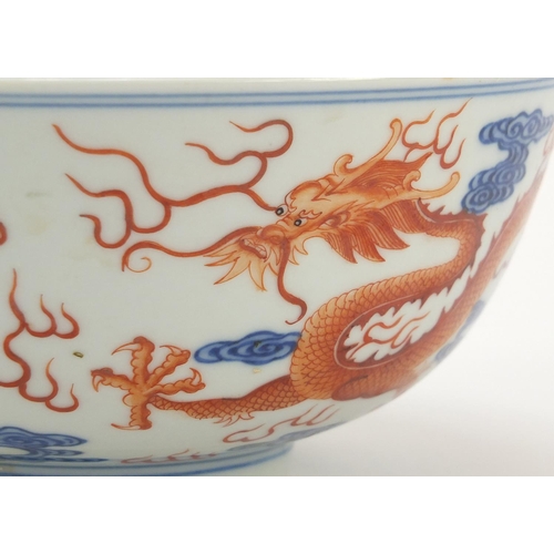 250 - Chinese iron red and blue and white porcelain bowl, finely hand painted with two dragons chasing a f... 