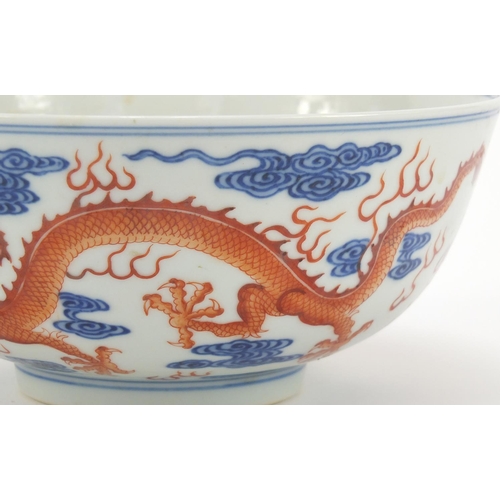 250 - Chinese iron red and blue and white porcelain bowl, finely hand painted with two dragons chasing a f... 