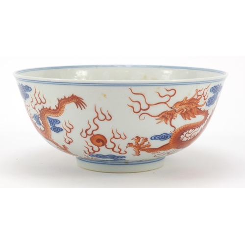 250 - Chinese iron red and blue and white porcelain bowl, finely hand painted with two dragons chasing a f... 