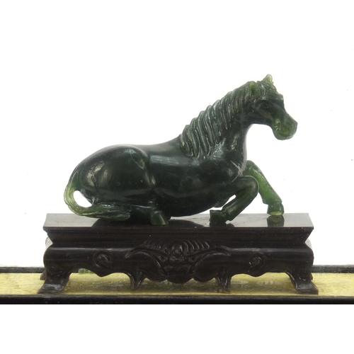 1550 - Chinese green horse, possibly hardstone, housed in a glazed case, overall 17cm H x 21cm W x 11cm D