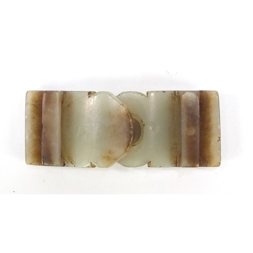 257 - Chinese russet and pale green jade two piece buckle carved with a lion's head, overall 8.5cm x 3.5cm