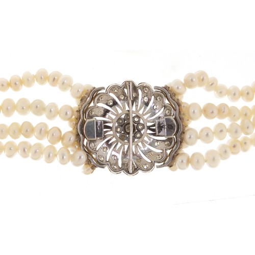 238 - Four row pearl necklace with a large unmarked white metal diamond set clasp, 40cm in length, the cla... 