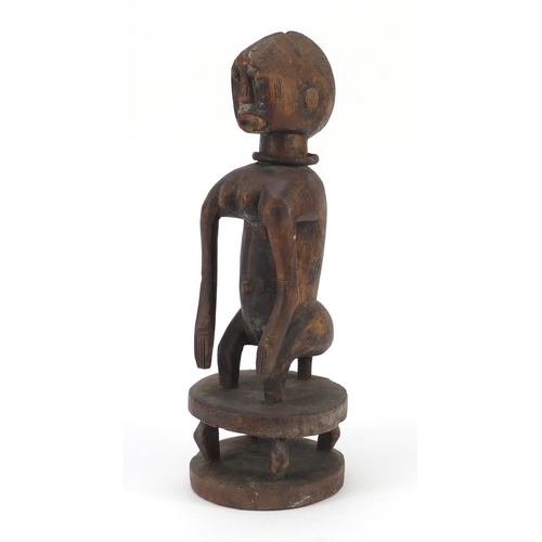 88 - African tribal interest carved wood squatting Chamber figure wearing an iron necklace, 39cm high