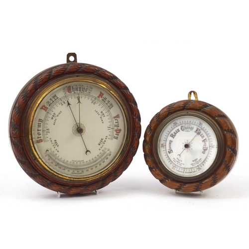 121 - Two carved oak rope twist design wall barometers, the largest 27cm in diameter