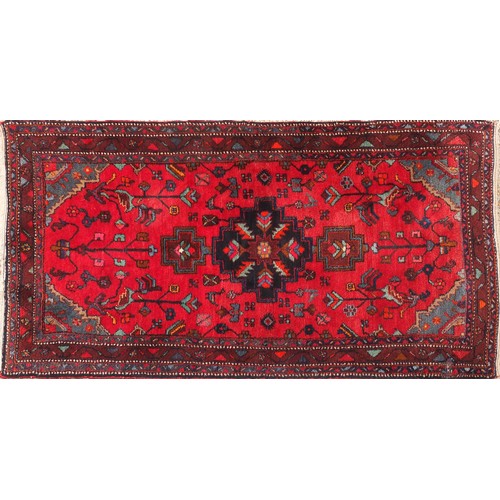 856 - Hand made Iranian rug decorated with floral pattern onto a red and blue ground, 240cm x 126cm