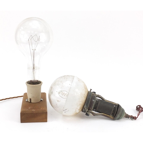 272 - Two large Industrial style bulbs, one on a gimbal support, the other mounted on a wooden block, the ... 