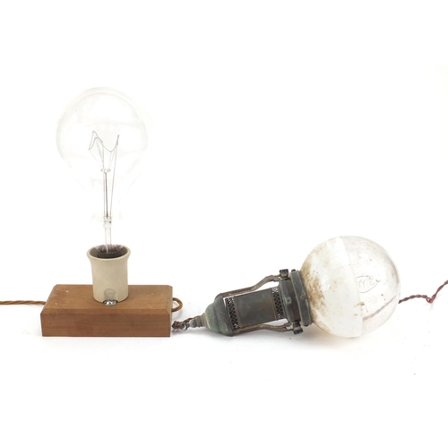 272 - Two large Industrial style bulbs, one on a gimbal support, the other mounted on a wooden block, the ... 