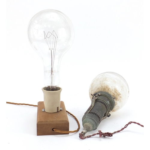 272 - Two large Industrial style bulbs, one on a gimbal support, the other mounted on a wooden block, the ... 