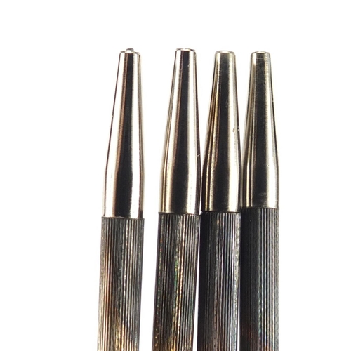 314 - Set of four silver bridge pencils with suit motifs and case, Birmingham 1947, each 9cm in length