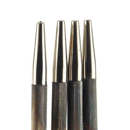 314 - Set of four silver bridge pencils with suit motifs and case, Birmingham 1947, each 9cm in length