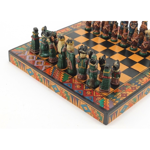 751 - Hand painted terracotta Aztec design folding chess set with board, the largest piece 6.5cm high