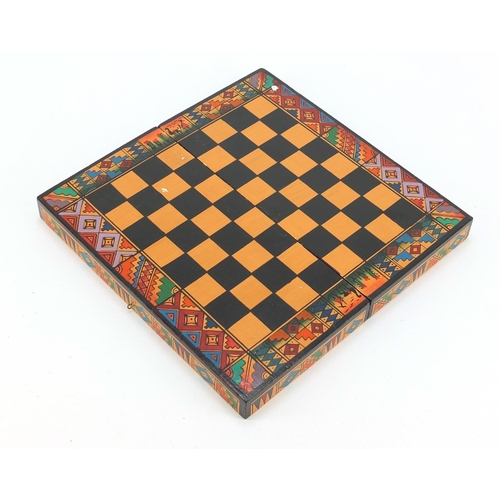 751 - Hand painted terracotta Aztec design folding chess set with board, the largest piece 6.5cm high