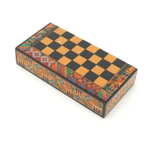 751 - Hand painted terracotta Aztec design folding chess set with board, the largest piece 6.5cm high