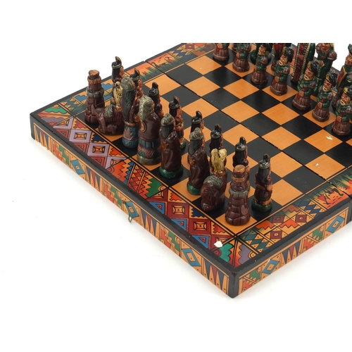 751 - Hand painted terracotta Aztec design folding chess set with board, the largest piece 6.5cm high