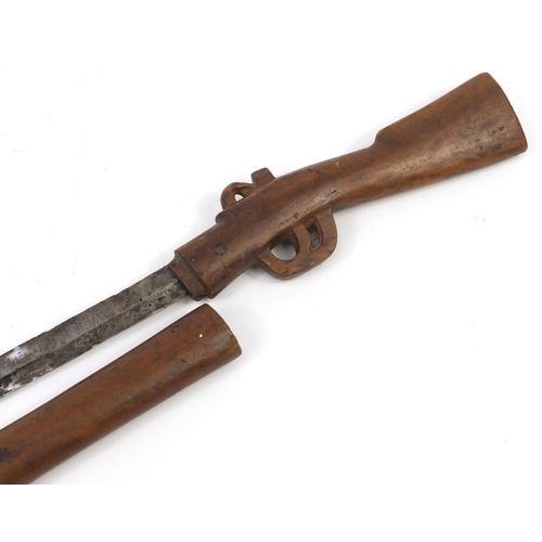 899 - African carved wood sword stick in the form of a rifle, 86cm in length