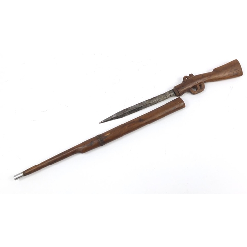 899 - African carved wood sword stick in the form of a rifle, 86cm in length