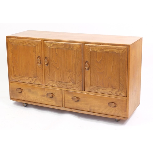 1307 - Ercol Windsor elm sideboard with three cupboard doors above two drawers, 76cm H x 130cm W x 43cm D