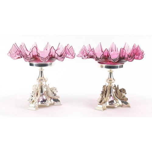 48 - Pair of silver plated and ruby glass tazzas cast with mythical winged creatures, numbered 2832, 25cm... 