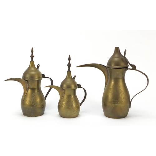 1980 - Graduated set of three Omani brass coffee pots, engraved marks to the bases, largest 18cm high