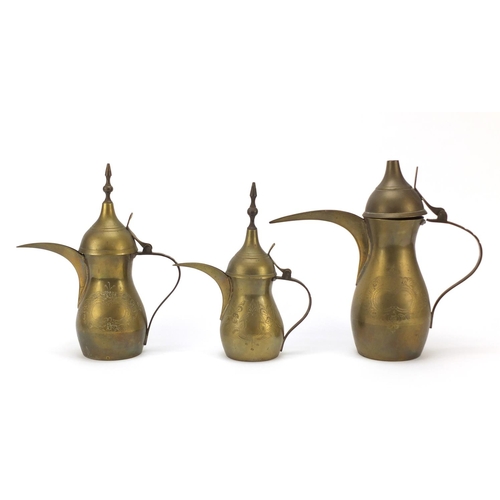 1980 - Graduated set of three Omani brass coffee pots, engraved marks to the bases, largest 18cm high