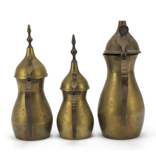 1980 - Graduated set of three Omani brass coffee pots, engraved marks to the bases, largest 18cm high