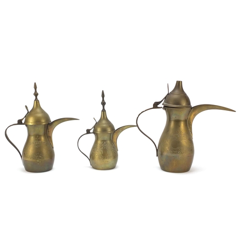 1980 - Graduated set of three Omani brass coffee pots, engraved marks to the bases, largest 18cm high