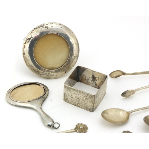 761 - Silver and white metal objects including two miniature photo frames, sugar tongs and teaspoons, vari... 