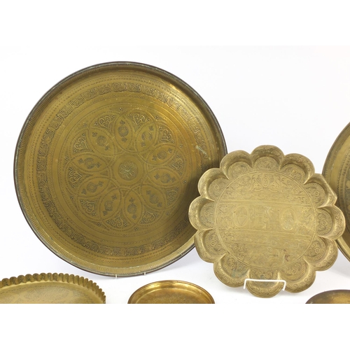 2002 - Six Middle Eastern brass trays and a gong, each engraved/embossed with figures and wild animals, the... 