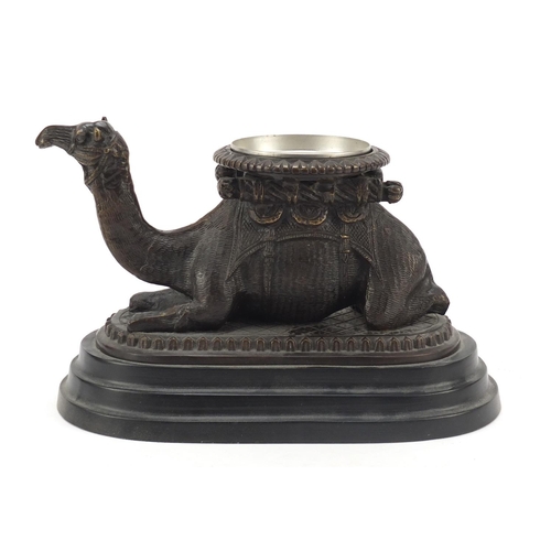 95 - Bronze model of a crouching camel raised on oval stepped base, 28cm in length