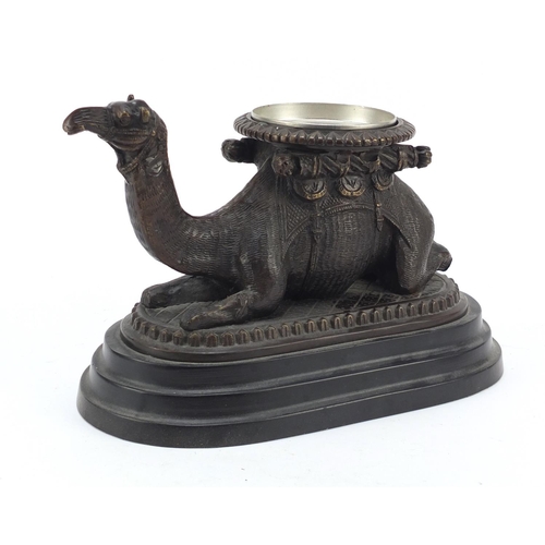 95 - Bronze model of a crouching camel raised on oval stepped base, 28cm in length