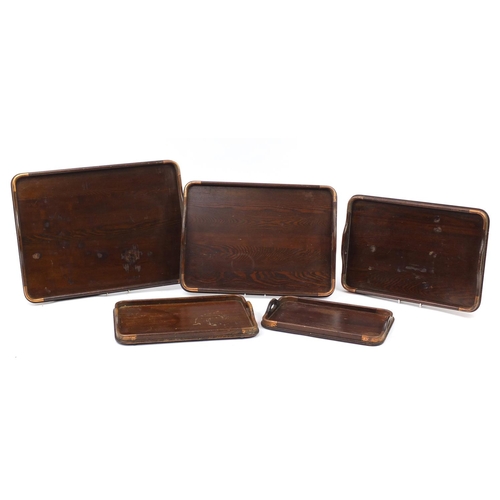 330 - Graduated set of five oak trays with copper mounts, the largest 62cm x 44cm