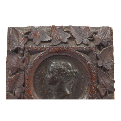 527 - Victorian Madras Exhibition bronze medallion housed in a Black Forest frame carved with foliage, 10c... 