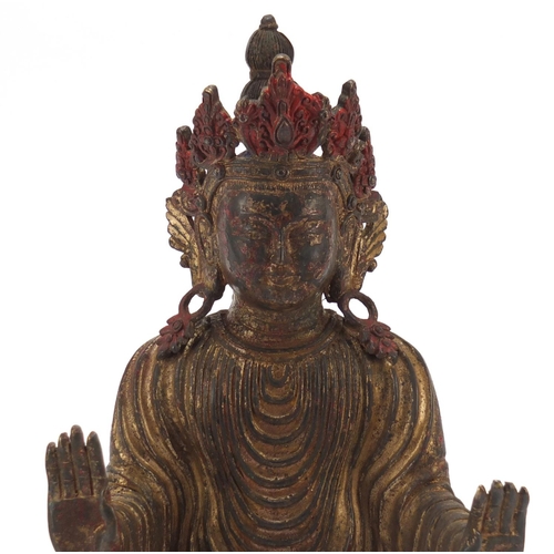 576 - Chino-Tibetan gilt bronze figure of standing Buddha with remnants of paint, 34cm high