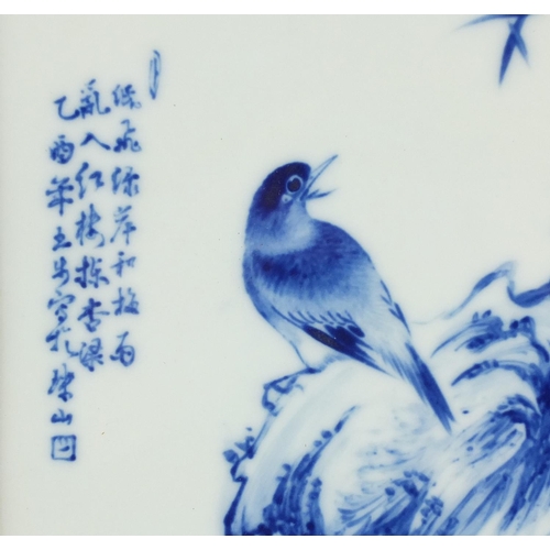 125 - Chinese blue and white panel housed in a carved hardwood frame, hand painted with a bird on a rock w... 