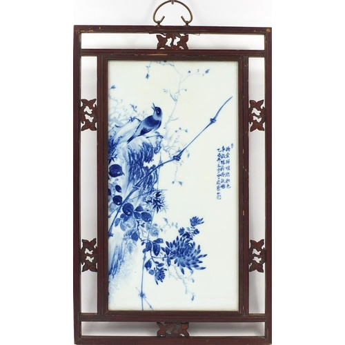 213 - Chinese blue and white panel housed in a carved hardwood frame, hand painted with a bird on a rock w... 