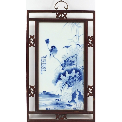 126 - Chinese blue and white panel housed in a carved hardwood frame, hand painted with a bird on a rock w... 