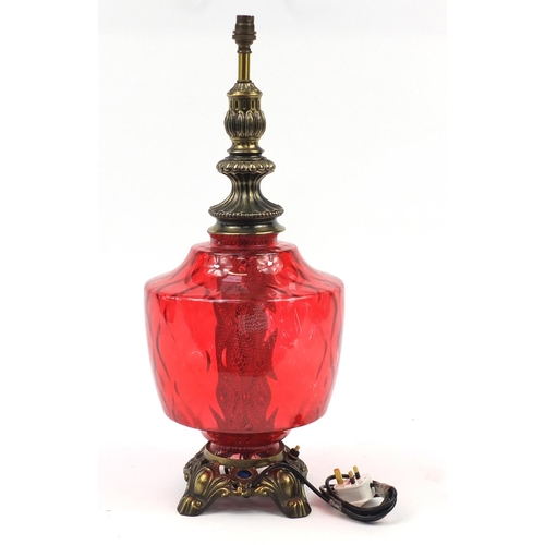 2009 - Ornate gilt metal lamp with cranberry coloured glass body, 65cm high