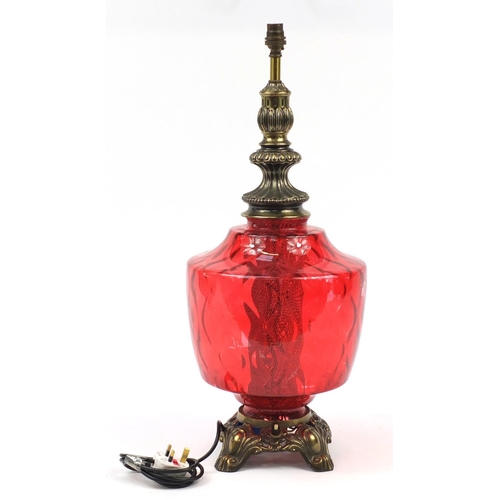 2009 - Ornate gilt metal lamp with cranberry coloured glass body, 65cm high