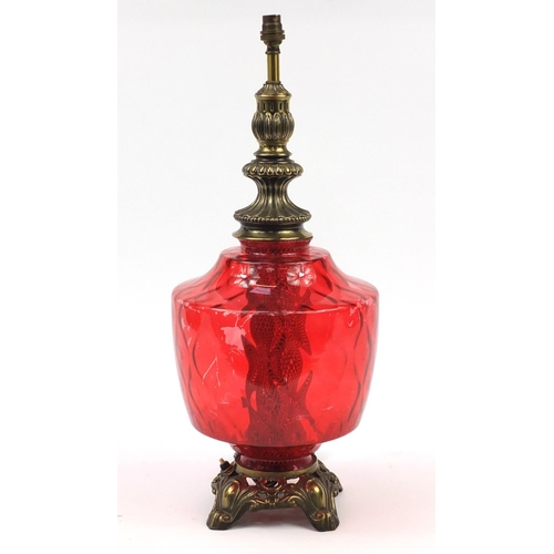 2009 - Ornate gilt metal lamp with cranberry coloured glass body, 65cm high