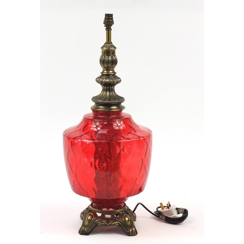 2009 - Ornate gilt metal lamp with cranberry coloured glass body, 65cm high