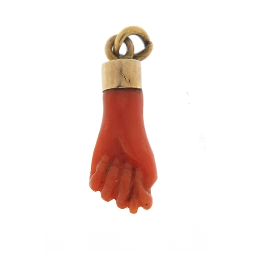 274 - Victorian carved coral pendant in the form of a clutched hand with unmarked gold mount, 2.5cm in len... 