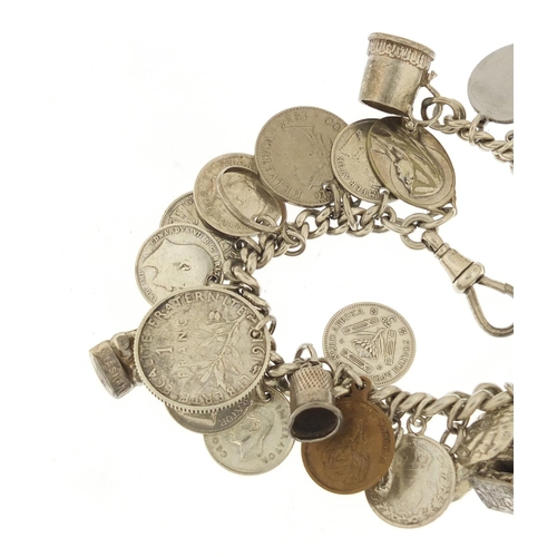 523 - Silver charm bracelet with a selection of mostly silver charms and coins, 87.0g