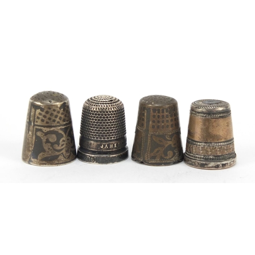 762 - Four silver thimbles including one with a Stanhope and niello work, the largest 2.2cm high, 24.0g