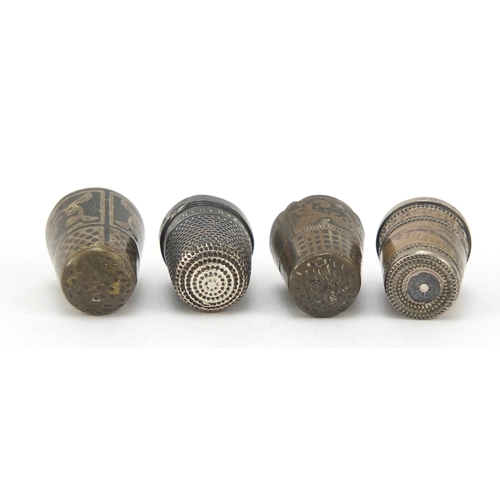 762 - Four silver thimbles including one with a Stanhope and niello work, the largest 2.2cm high, 24.0g