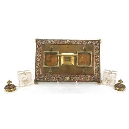 331 - 19th century copper and brass desk stand with two cut glass inkwells, the stand embossed with cherub... 