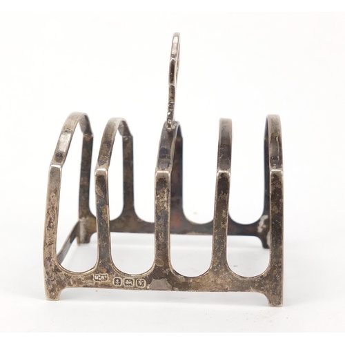 539 - Silver items comprising four slice toast rack, shell shaped dish and hand mirror, various hallmarks,... 