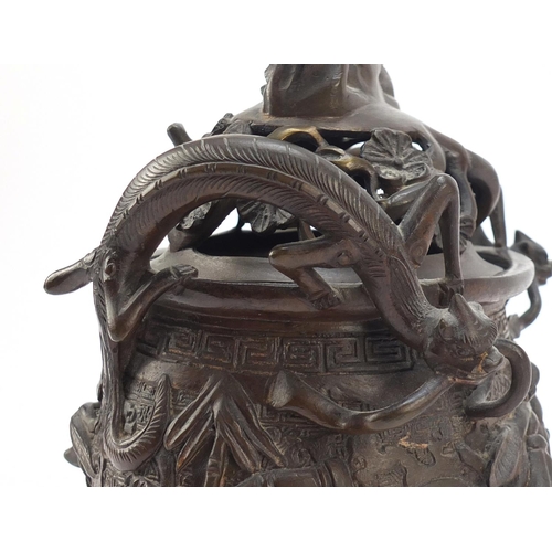 224 - Chinese patinated bronze tripod censer with figural cover, 27cm high